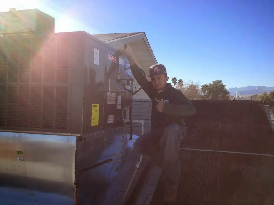 HVAC technician performing Air Duct Repair on a rooftop unit in Piscataway